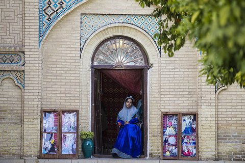 زنی با لباس محلی در آرامگاه حافظ