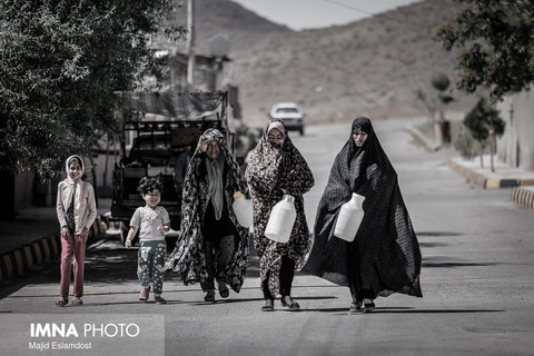 زنان روستا به همراه کودکان خود برای گرفتن آب در حال حرکت هستند.
