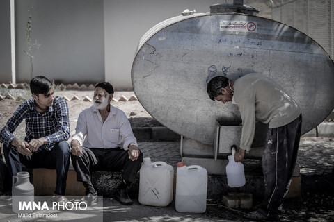 کارگری که در حال برداشت روزانه ی آب شرب خود است