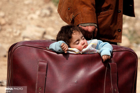 خوابیدن یک کودک سوری مهاجر در چمدان