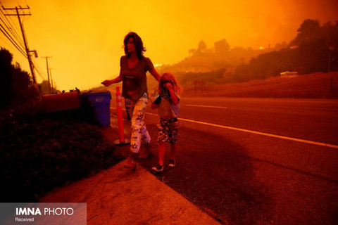 خروج یک زن و فرزندانش از محل زندگی‌شان به علت آتش سوزی کالیفرنیا