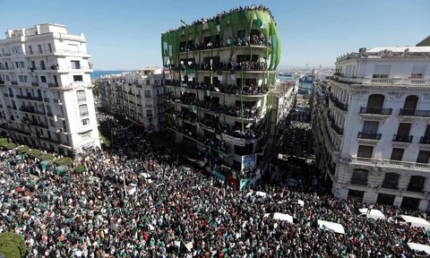 People gather during a protest over President Abdelaziz Bouteflika’s decision to postpone elections and extend his fourth term in office.