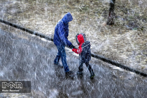زنی به همراه فرزند خود در بارش برف در بلاروس