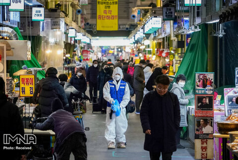 کارمند یک شرکت خدمات ضد عفونی کننده کف یک بازار سنتی در سئول کره جنوبی را ضد عفونی می کند