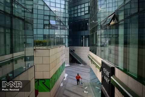 یک کارگر شهرداری پوشیده از ماسک در پکن در حال تمیز کردن مرکز تجاری 