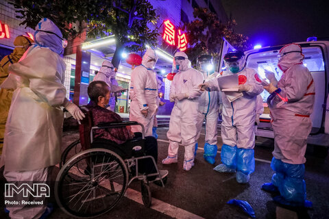 یکی از اعضای کادر پزشکی اطلاعات بیمار را برای انتقال به بیمارستان بیماران مبتلا به کرونا ویروس در شهر ووهان چین جمع آوری می کند