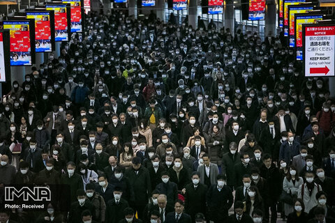 جمعیت زیادی از مردم با ماسک در توکیو در حال رفت و آمد هستند