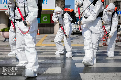 سربازان کره‌جنوبی با پوشیدن وسایل محافظ در پایتخت سئول کره جنوبی یک خیابان را در مقابل تالار شهر ضد عفونی می کنند