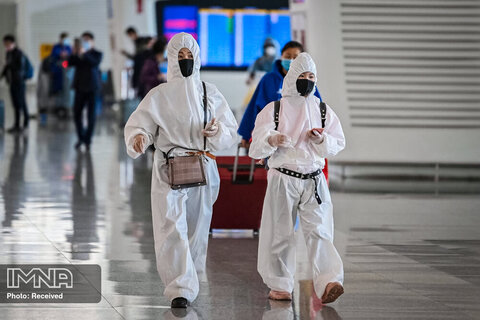 قدم زدن مسافران با لباس های محافظ پس از ورود به فرودگاه ووهان چین