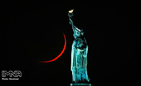 ماه در شهر نیویورک پشت مجسمه آزادی غروب می کند