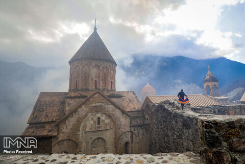 یک مرد ارمنی با پرچم ملی ارمنستان از صومعه ارتدوکس در حومه کالباجار ، منطقه جدایی طلب قره باغ بازدید می کند