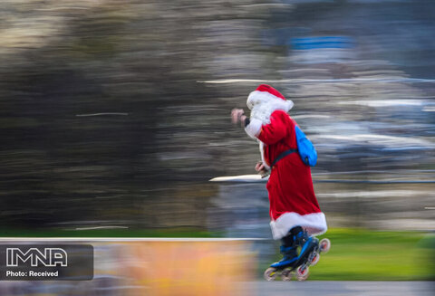 مردی که لباس بابانوئل را پوشیده با اسکیت غلتکی در درسدن ، آلمان