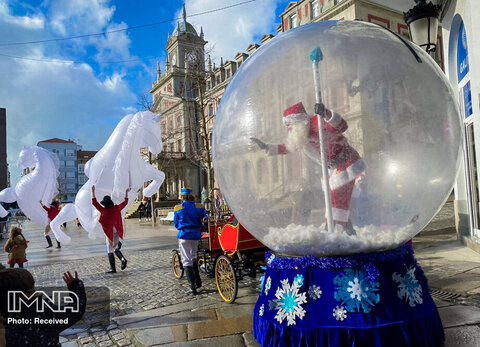 مردی که لباس بابا نوئل را بر تن کرده و از داخل یک توپ پلاستیکی در شمال غربی اسپانیا، برای کودکان تکان می دهد. گالیسیا، اسپانیا