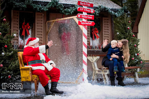 نوح لکلر ، یک و نیم ساله و مادرش جنیفر آموس از طریق پلکسی گلاس به بابا نوئل نگاه می کنند تا از ویروس کرونا در امان بمانند. انتاریو، کانادا