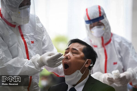  پرسنل کادر درمان با لباس محافظتی ویژه برای انجام تست کووید 19  در هانوی ویتنام

