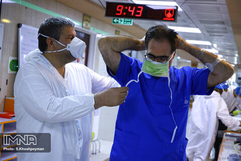 کادر درمان بیمارستان امین در حین آماده سازی دکتر کاظمیان برای ویزیت بیماران.