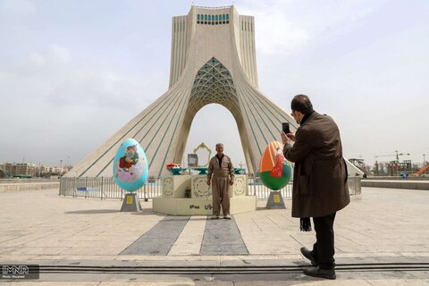 یک مرد کردایرانی در حال عکس گرفتن در مقابل برج آزادی تهران در ایام نوروز 