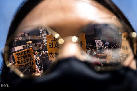 انعکاس تصویر معترضان در عینک یک شرکت کننده در تجمع علیه جنایات نفرت ضد آسیایی در نیویورک آمریکا
