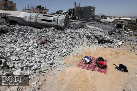  نمازگزاران مسلمان فلسطینی در نزدیکی آوارهای یک مسجد تخریب شده در بیت لاهیا  در شمال نوار غزه در حال برگزاری نماز جماعت هستند.