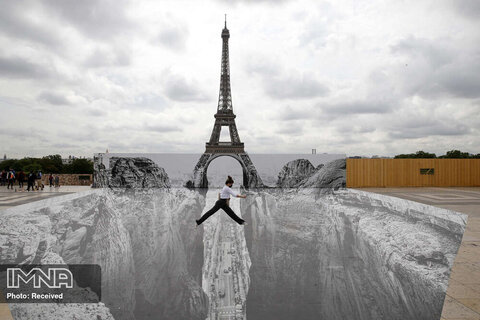 پرش زنی از روی اثر هنری ترامپ لویا (trompe l'oeil)، گرفته شده توسط ژان رنه، عکاس و هنرمند خیابانی فرانسوی معروف به JR. موقعیت: روبه‌روی برج ایفل.