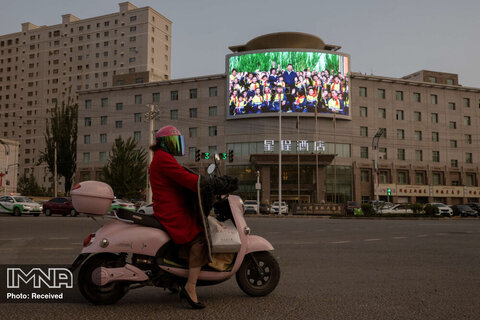 صفحه نمایشی در یک تقاطع واقع در هوتان که تصویری از شی جین پینگ، رئیس‌جمهور چین را در منطقه خودمختار سین کیانگ اویغور، چین نشان می‌دهد. تصویر گرفته شده در 30 آوریل 2021.