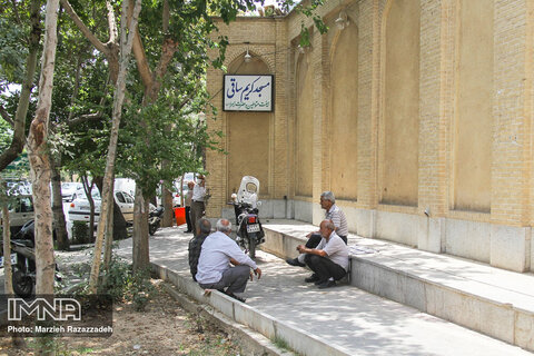 بازنشسته های محله در کنار دیواره مسجد کریم ساقی گرد هم می آیند و تا نزدیک اذان به معاشرت و هم صحبتی مشغولند