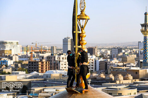اهتزاز پرچم عزای حسینی بر فراز گنبد حرم رضوی