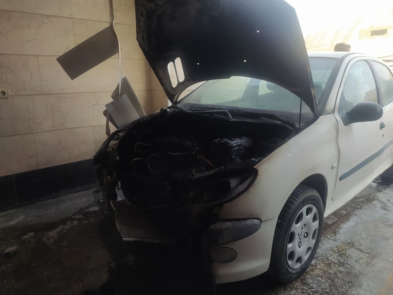 حریق خودروی ۲۰۶ در پارکینگ مجتمع مسکونی + عکس