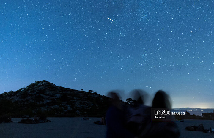مردم در طول بارش شهابی در جزیره لاستوو، کرواسی در 12 اوت، رگه های شهاب سنگ را در آسمان شب تماشا می کنند.