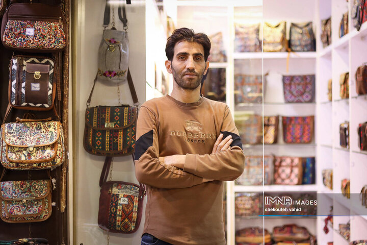 حمیدرضا 38 ساله، حدود بیست سال است در بازار مشغول فروش کیف های طرح دارِ سنتی، نمدی، چاپی و ترمه است.