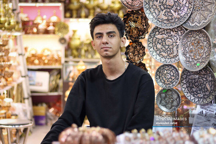 میلاد 21 ساله، دو سال است در بازار اصفهان فروشنده سماور و ظروف برنجی و مسی است.