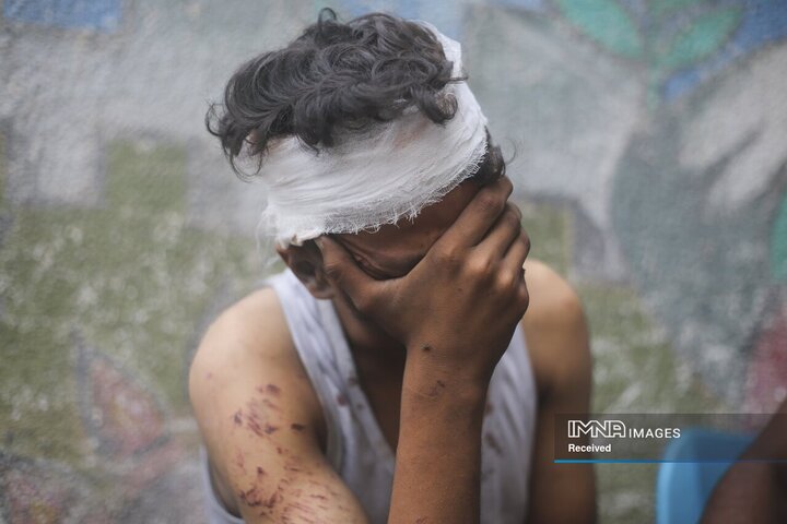 یک پسر فلسطینی در سوگ بستگان خود که در بمباران نوار غزه توسط اسرائیل در رفح در 23 اکتبر 2023 کشته شدند به سوگ نشسته