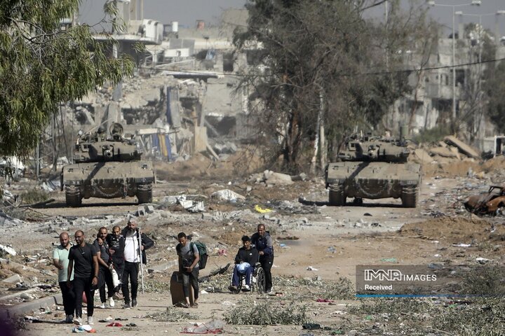 در حالی که تانک های اسرائیلی جاده صلاح الدین در نوار غزه مرکزی را در 24 نوامبر 2023 مسدود می کنند، مردان فلسطینی به شمال غزه می‌روند. آتش بس در جنگ اسرائیل و حماس به عنوان بخشی از توافقی که قطر به واسطه آن کمک کرد آغاز شد.