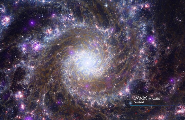 تصویری از یک کهکشان مارپیچی مانند کهکشان راه شیری خودمان، معروف به مِسیه 74، در یک تصویر ترکیبی که توسط تلسکوپ جیمز وب گرفته شده و توسط ناسا در 23 می 2023 منتشر شد، دیده می شود. بازوهای درخشان کهکشان از یک هسته سفید درخشان بیرون می آیند. شبکه‌های گرد و غبار کدر از فضای بین بازوهای آبی نقره‌ای منحنی، که به عنوان خطوط گرد و غبار نیز شناخته می‌شوند، می‌گذرد.
