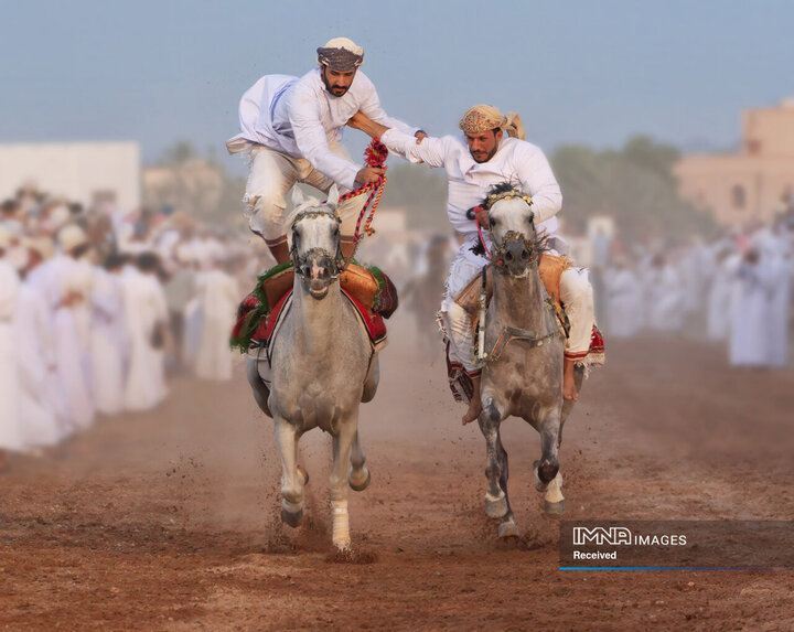مسابقات اسب‌دوانی، عمان
یکی از شرکت‌کنندگان رقیب خود را از افتادن از روی اسب حمایت می‌کند.