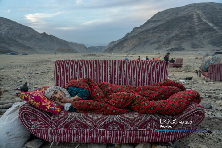 یک زن افغان در صحرا، نزدیک اردوگاهی که افراد اخیراً از پاکستان اخراج شده‌اند، در نزدیکی مرز پاکستان و افغانستان، در حال استراحت است. تورخم، افغانستان، 17 نوامبر 2023»
