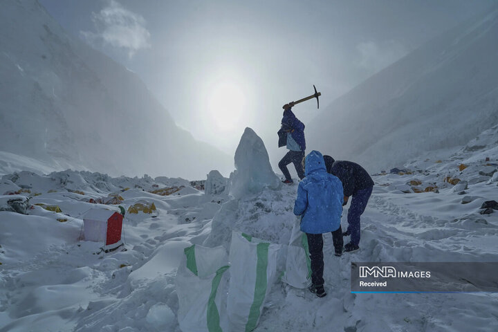 کوهنوردان در کمپ شماره 1 صعود در حال جمع‌آوری یخ برای آب شرب