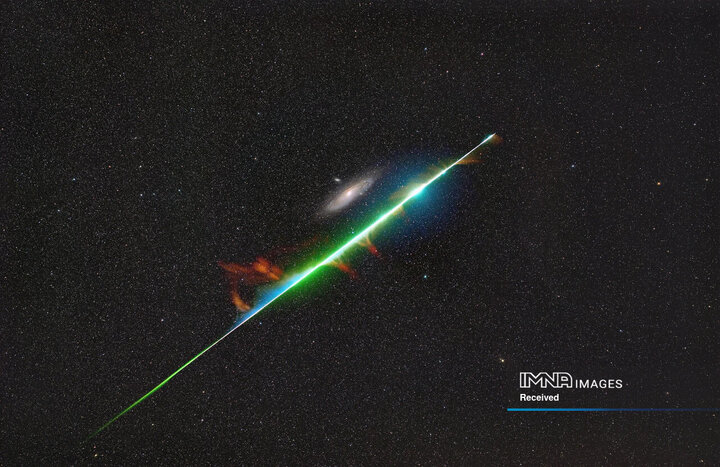 یک گوی آتشین درخشان از بارش شهابی برساوشی، کهکشان آندرومدا را خراش می‌دهد.