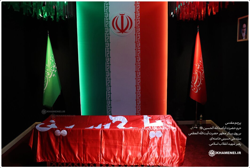 پرچم قرمز امام حسین (ع) بر پیکر رهبر شهید نماد خونخواهی است
